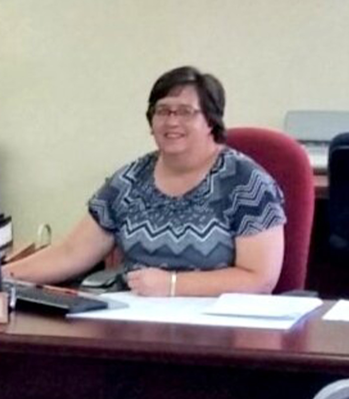 Meet Our Team - Professional and Welcoming Group at a Conference Table Faces the Camera, Team Leader Sitting on the Table with Arms Folded